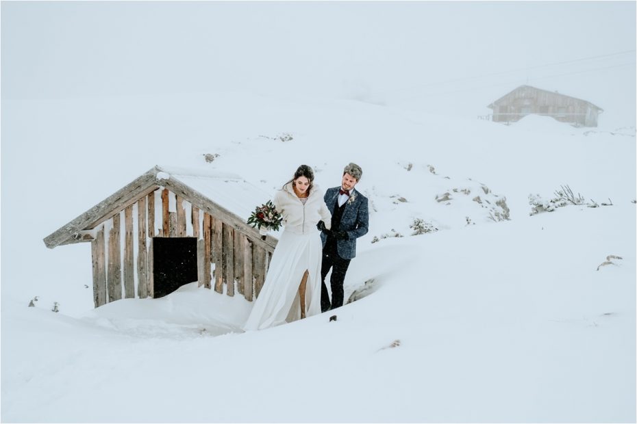 Bride and groom walk through deep snow on their wedding day in the Austrian Alps. Photos by Wild Connections Photography