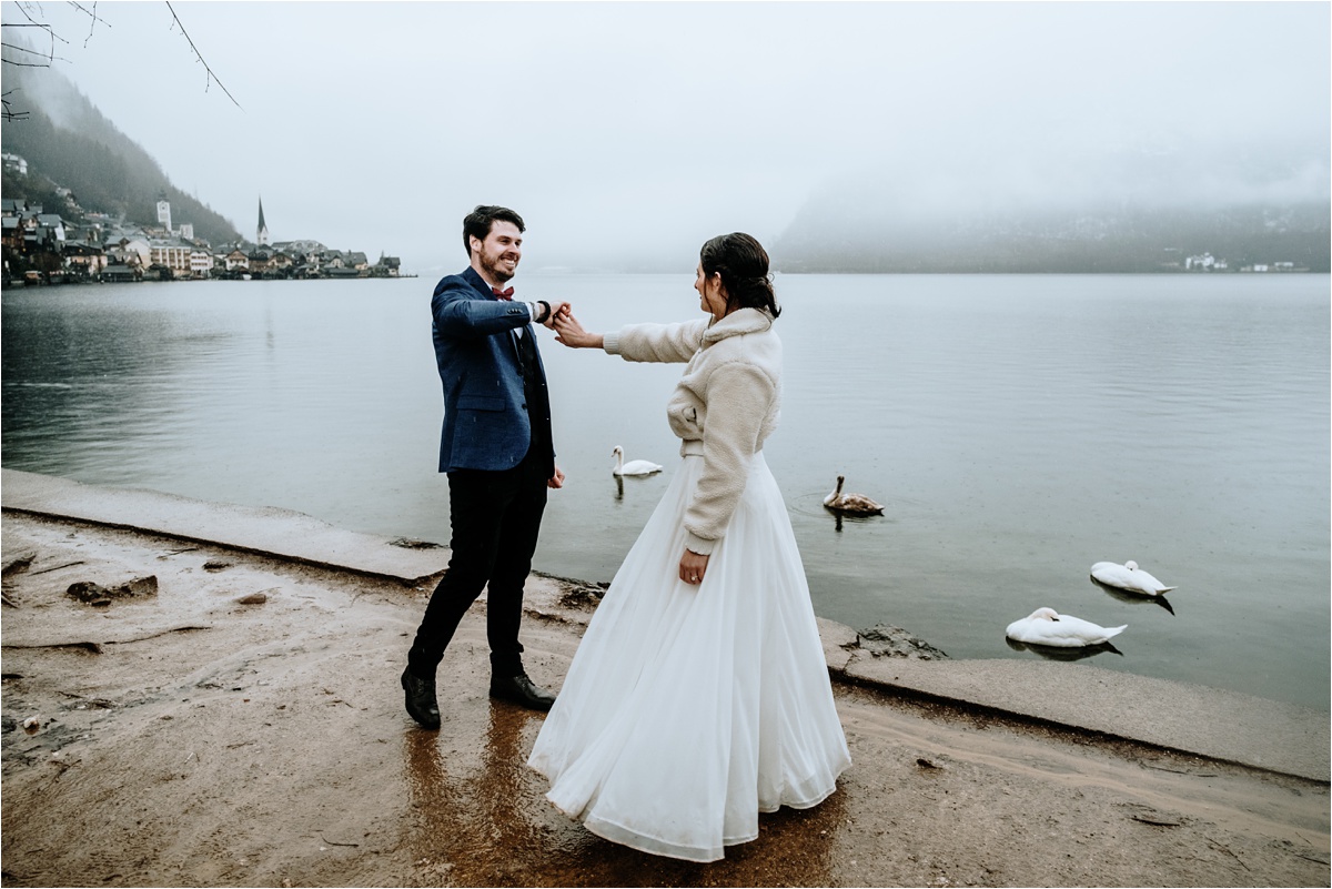 A couple who chose to elope in Austria dance in the rain