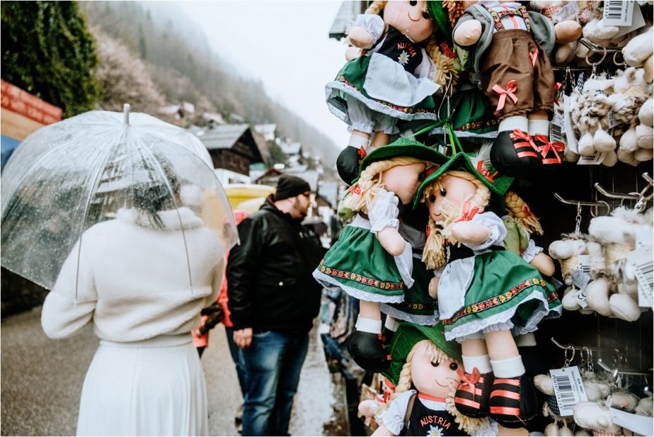 Bride and groom walk past a souvenir stand in Hallstatt Austria. Photos by Wild Connections Photography