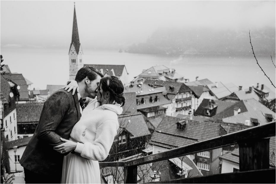 A bride and groom kiss on the stairs of Hallstatt in Austria on their wedding day. Photos by Wild Connections Photography
