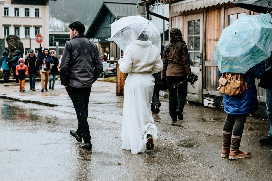 Bride and groom walk through Hallstatt in the rain. Photos by Wild Connections Photography