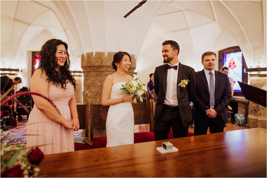 Kelly and Arik stand to say their wedding vows in the golden roof in Innsbruck for their civil wedding ceremony by Wild Connections Photography
