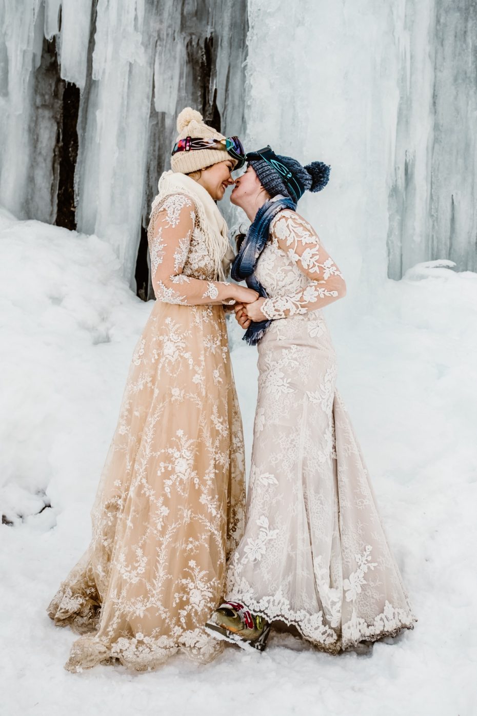 Two brides kiss under a frozen waterfall in Tirol in the Austrian Alps by Wild Connections Photography