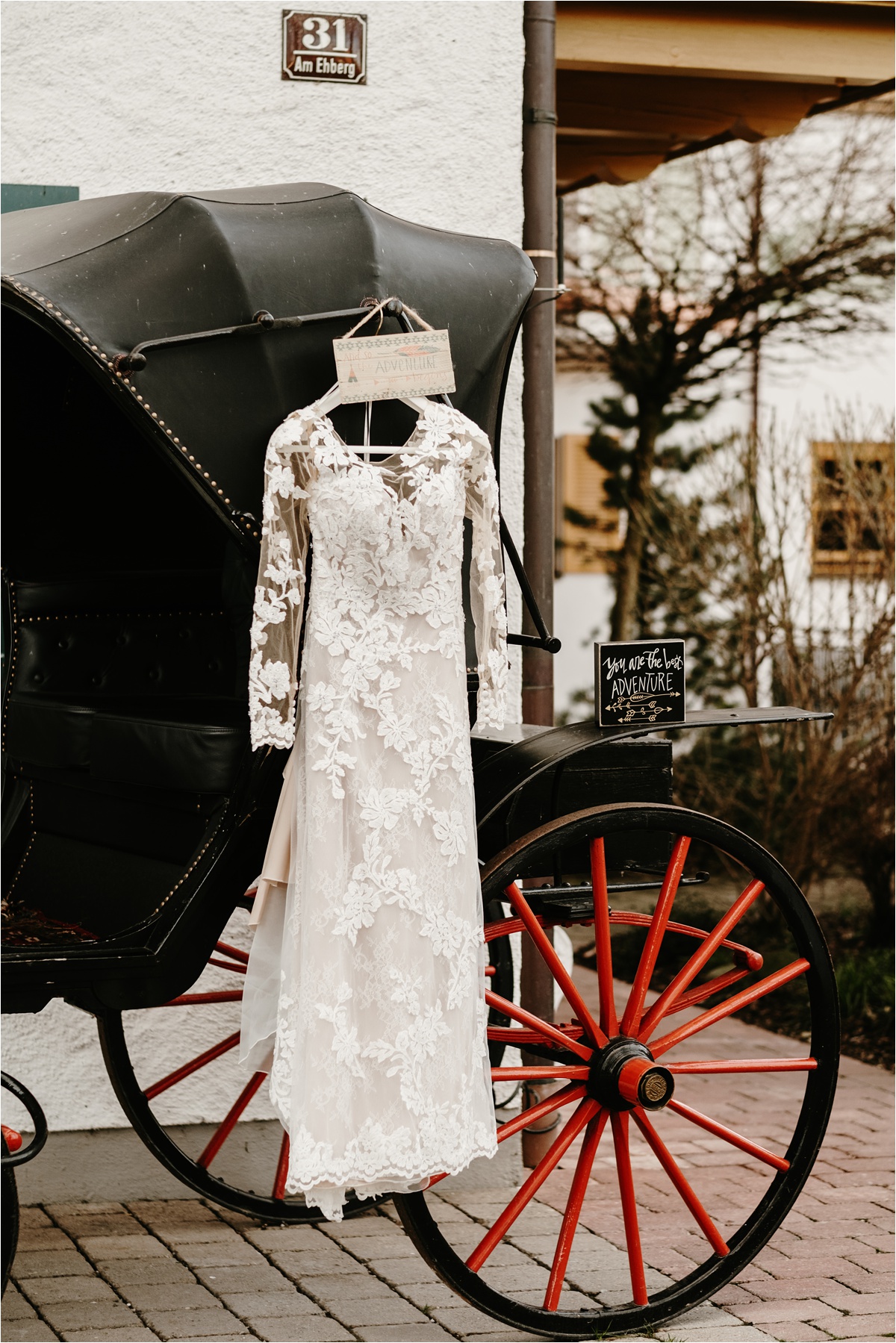 Pronovias wedding dress hangs outside the venue for this LGBT elopement in the Bavarian Alps. Photo by Wild Connections Photography