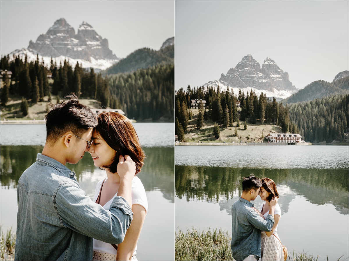 The engaged couple stand facing each other with their foreheads touching at Lake Misurina in the Dolomites. Photo by Wild Connections Photography Dolomites Wedding Photographer
