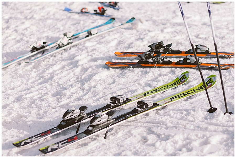 Skis lying on the floor in the snow at the bottom of a ski run