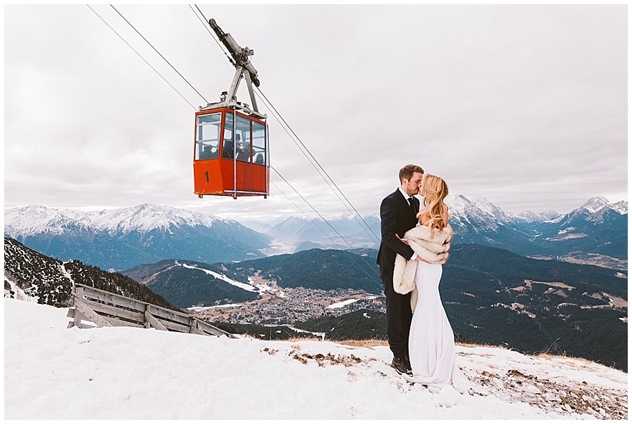 Seefeld Svatební polibek nevěsty a ženicha pod lanovkou, která dopravuje hosty nahoru na sjezdovku od Wild Connections Photography