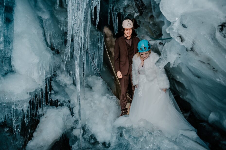 Bride and groom wear helmets inside an ice cave in the glacier