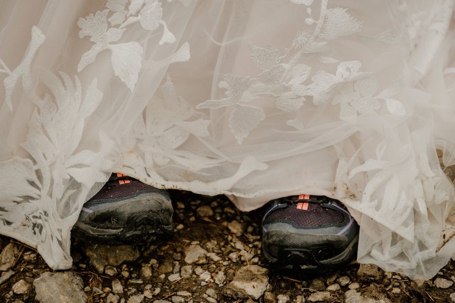 Hiking boots sticking out under a muddy wedding dress