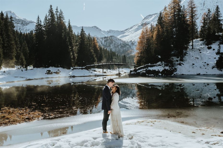 Bride and groom standing close facing one another at a fronzen mountain like in Tyrol in the Austrian Alps
