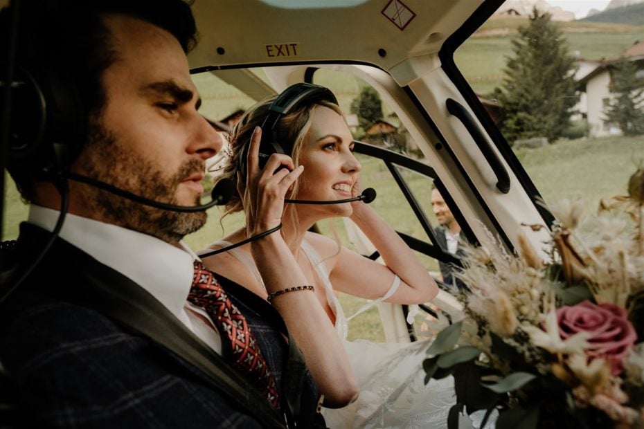 Bride and groom put on headsets in the heli for their helicopter wedding in the Alps