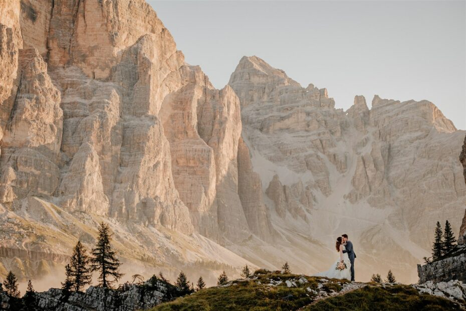 Bride and groom kiss against the majestic backdrop if the Italian Dolomites at sunrise