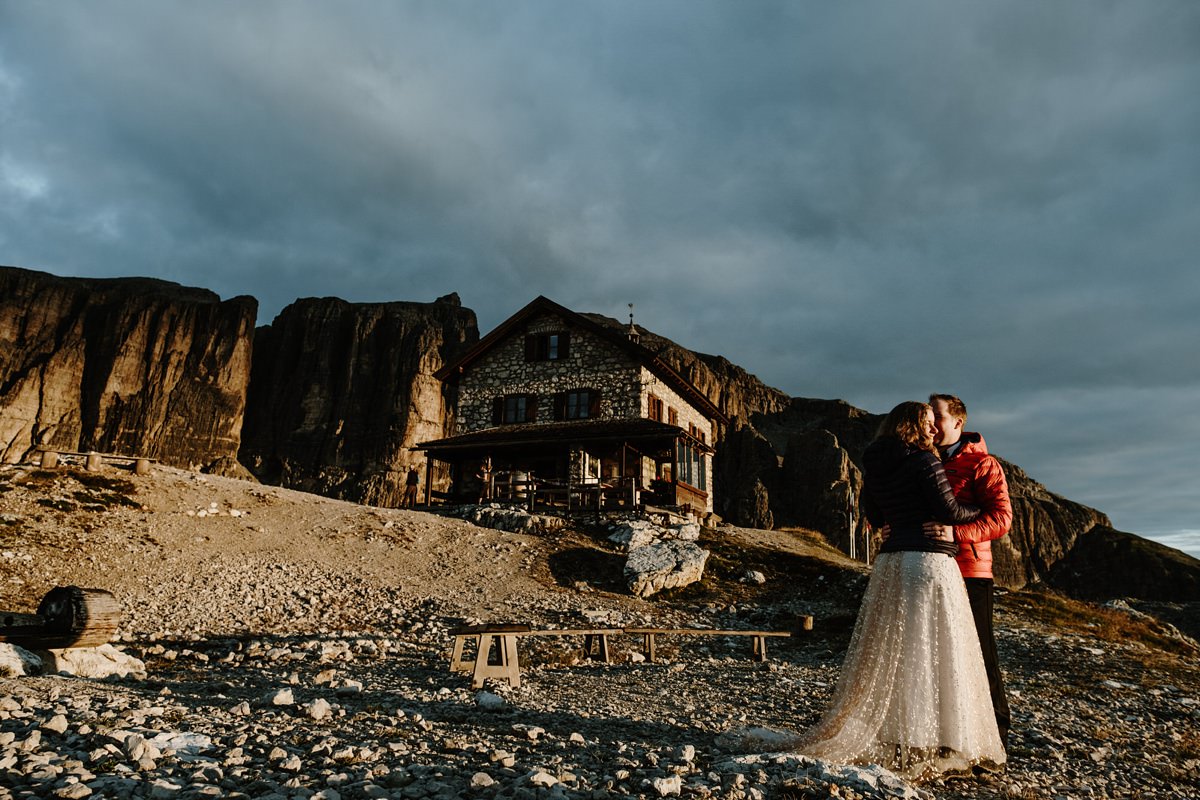 Bride and groom outside a mountain hut in the Dolomites