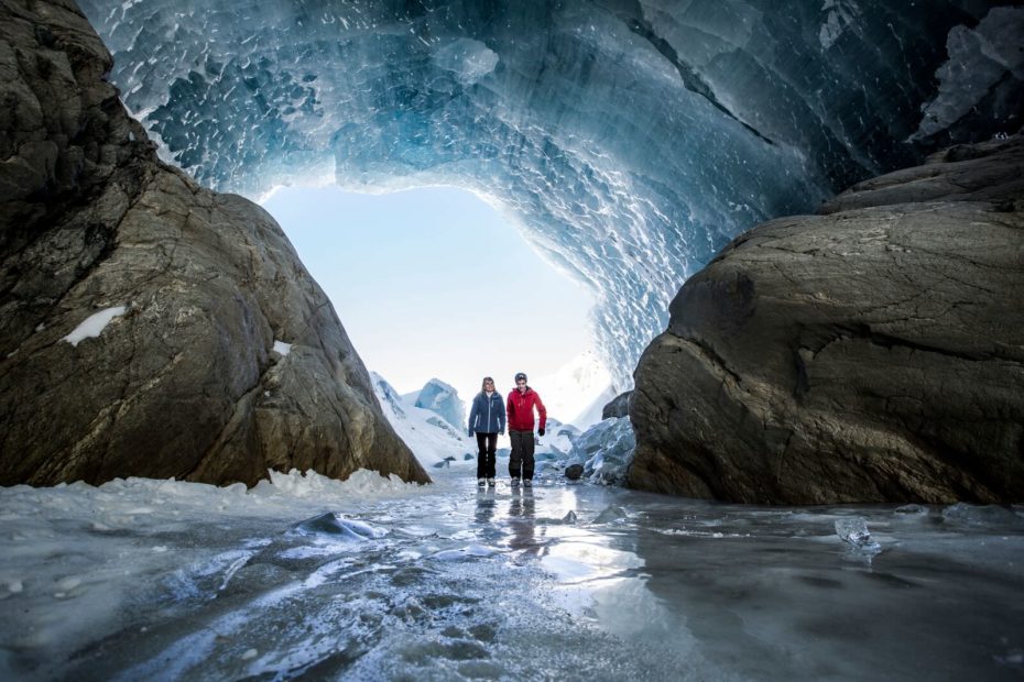 Man and woman walking in an ice cave in the Austrain Alps