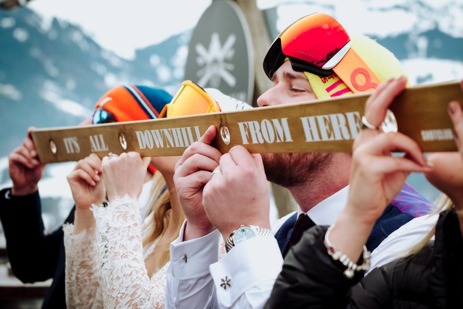 bride and groom drink from a shot ski during an after-wedding party