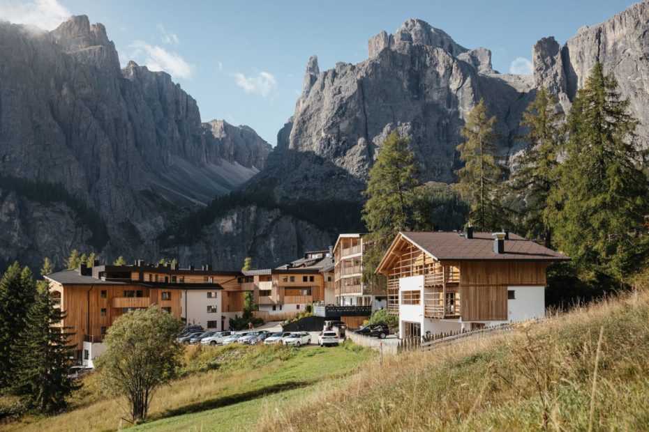 Luxusní hotel Kolfuschgerhof v Colfoscu v Dolomitech, hotel obklopený zelenými loukami a strmými skalnatými horami