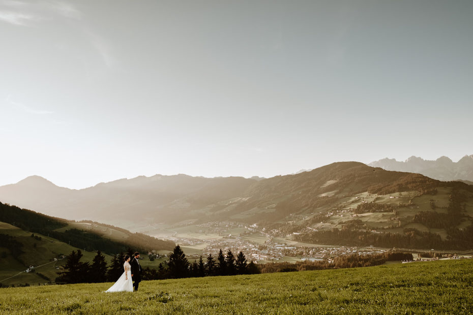 Bride and groom in a green alpine meadow in the Tirol region of the Austrian Alps