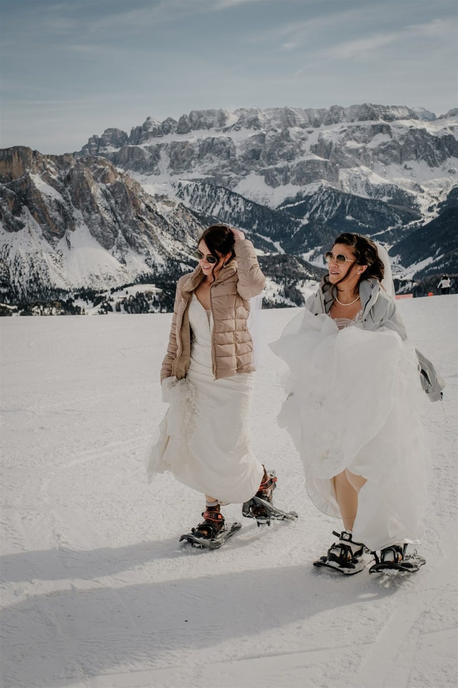 Two brides hike in snowshoes to their winter elopement