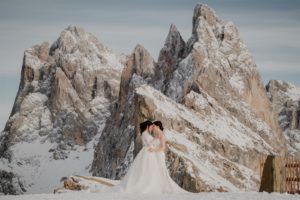Two brides in front of Seceda mountain in winter with snow on the ground