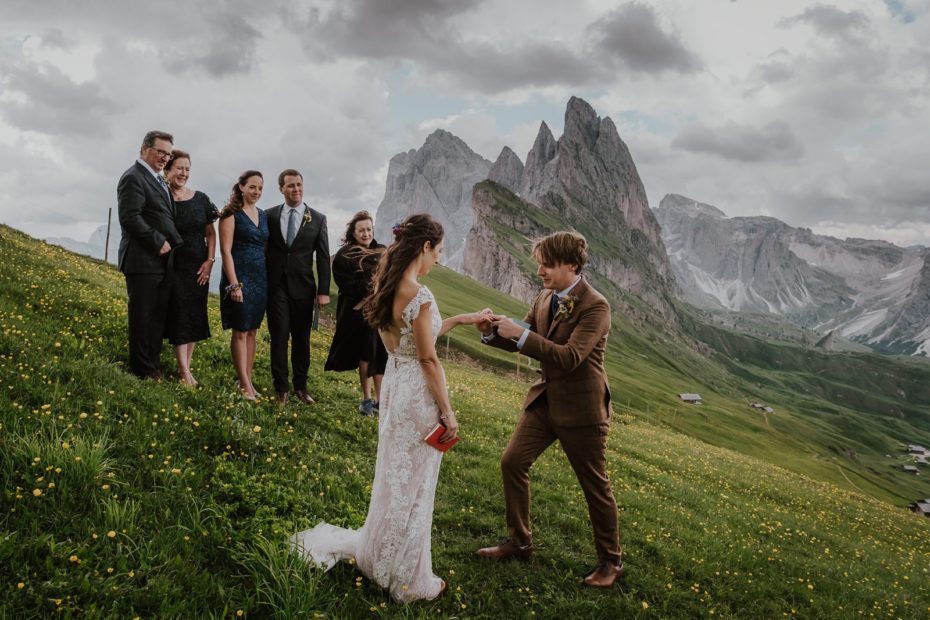 elopement ceremony on Seceda in the Dolomites, the groom gives the bride a ring with the mountains in the background