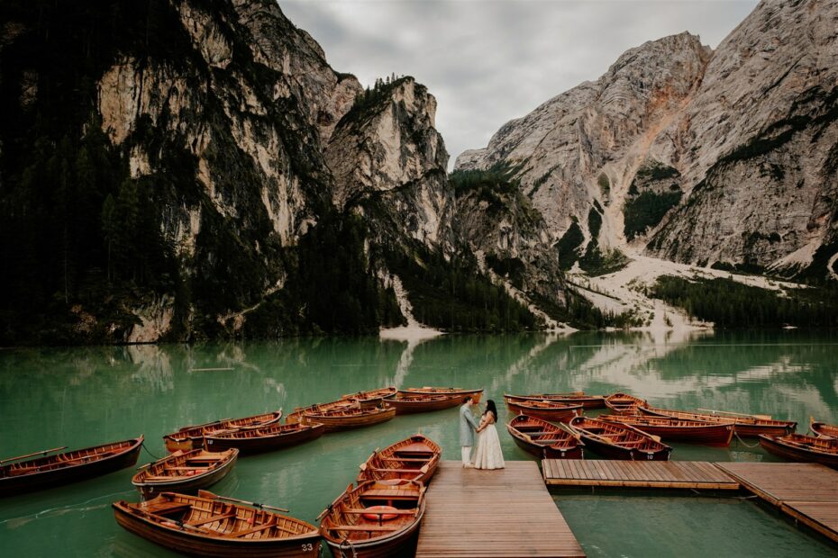 Lago di Braies elopement wedding on the boathouse, bride and groom stand on the dock in Indian wedding clothes