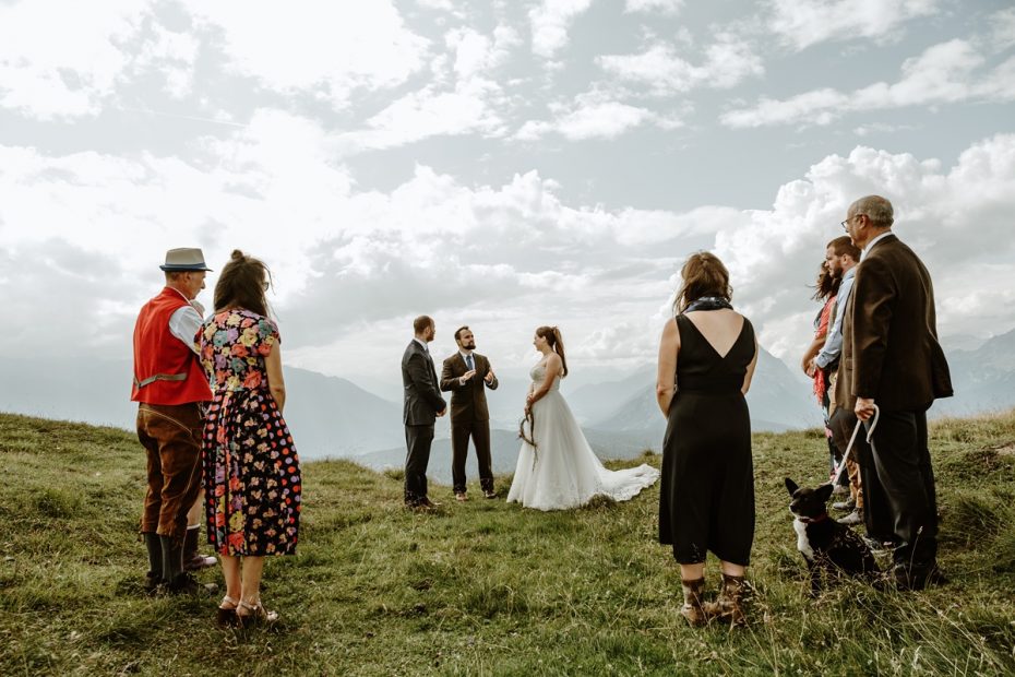 Family gather around bride and groom after hiking to mountain top to witness elopement ceremony