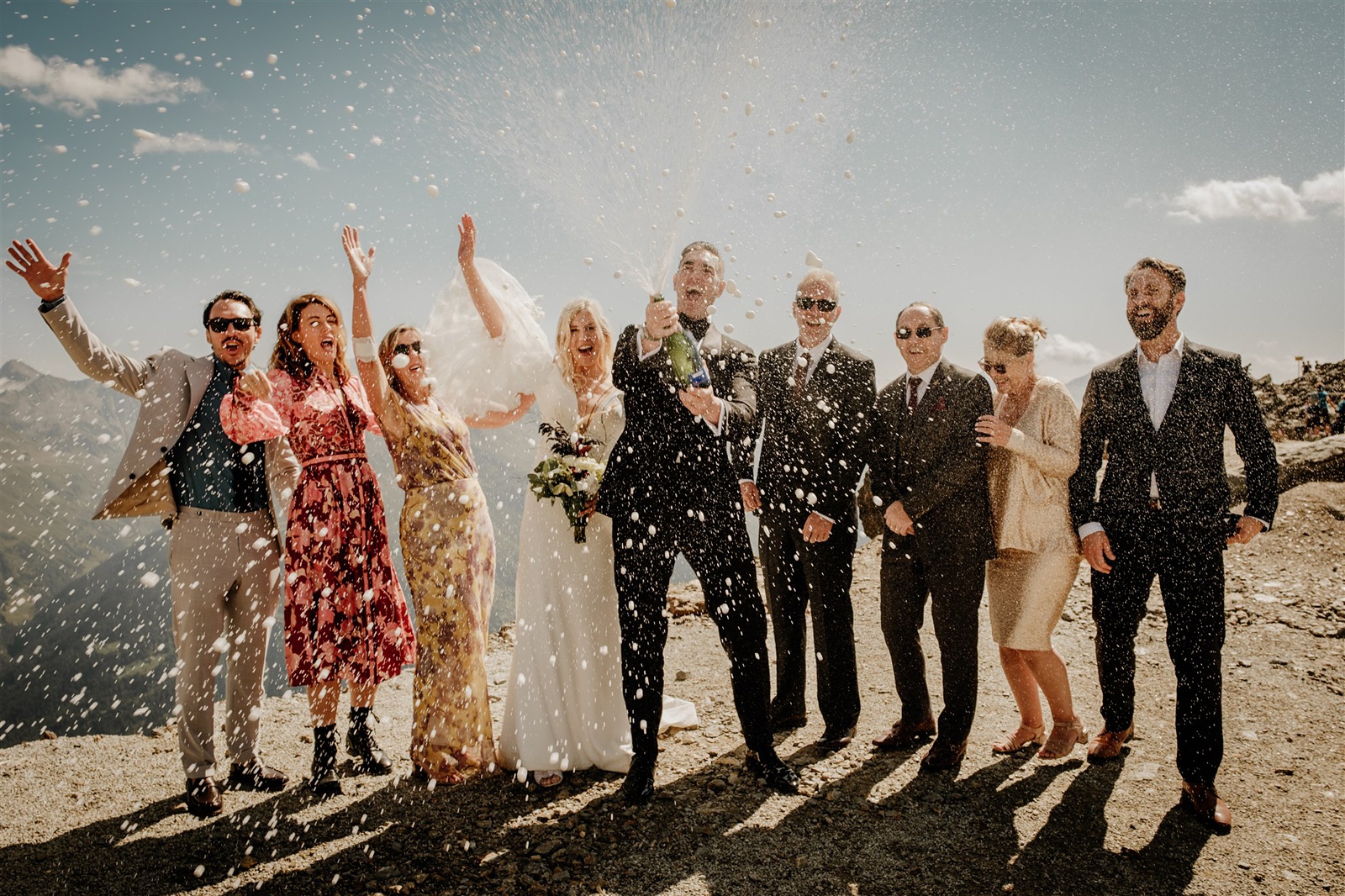Wedding party spray a champagne bottle on the top of the mountain in Sölden in Austria