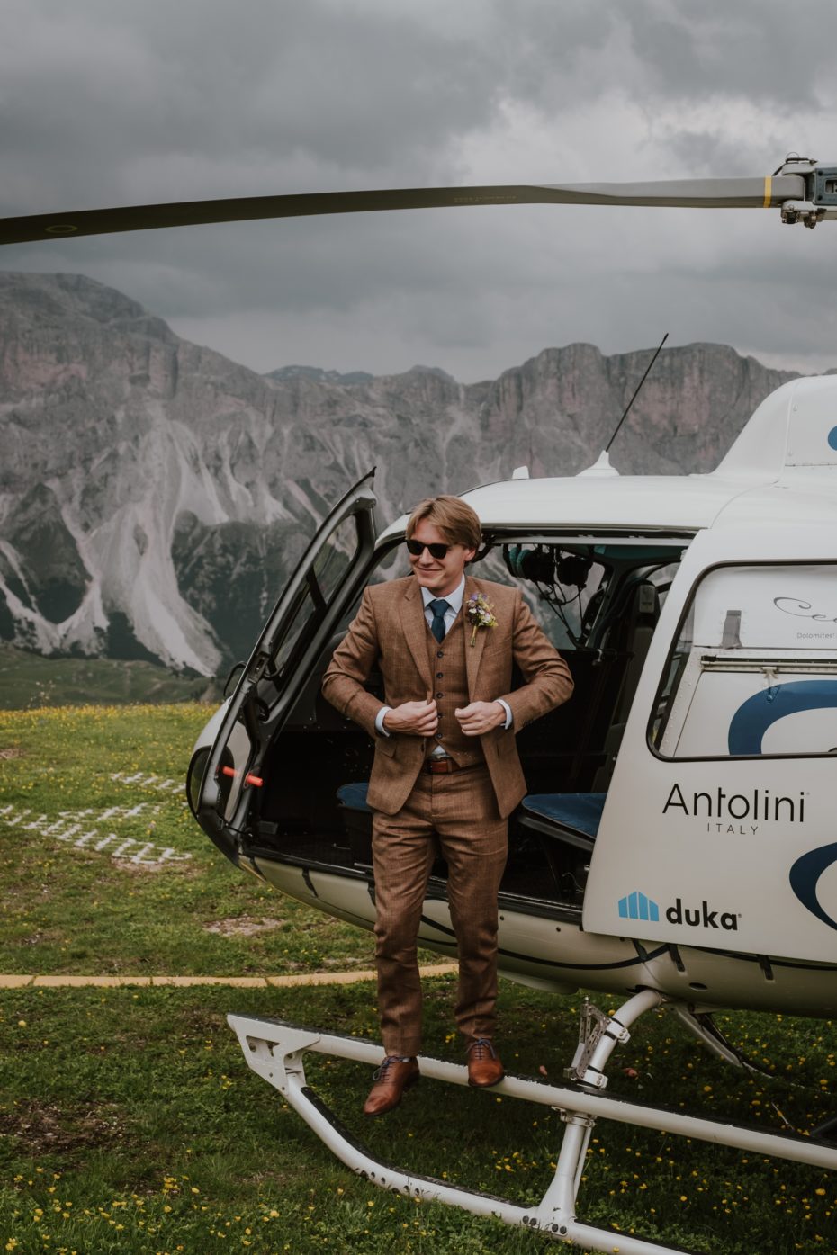 Groom arrives at the wedding ceremony in the Dolomites by helicopter
